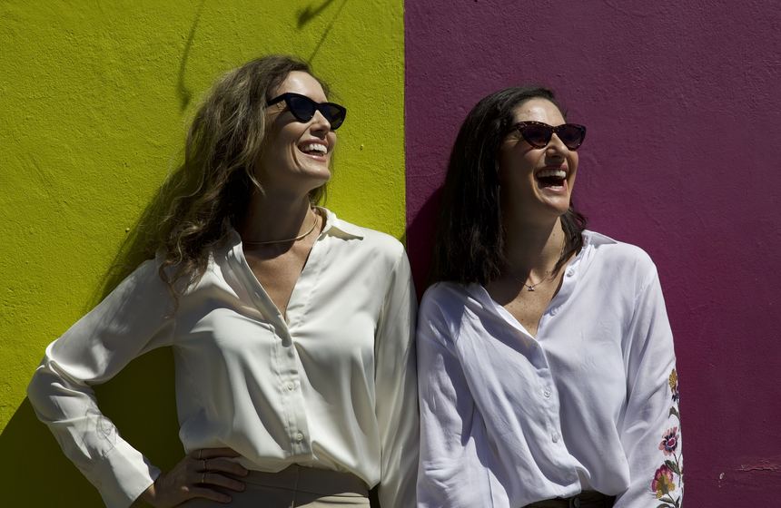 Tara and Haylea laughing against a colourful Cape Town wall